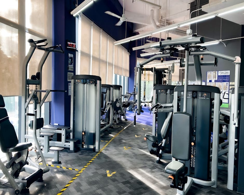 Clean and welcoming local gym environment featuring specialized strength equipment and bright ventilation